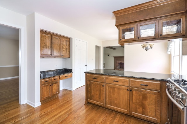 416 E Bauer Rd, Naperville, IL 60563 - kitchen with stainless steel gas range, wood finished floors, glass insert cabinets, and dark stone countertops