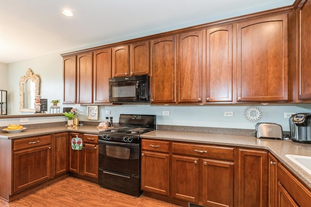 2835 Cattail Ct Unit B, Wauconda, IL 60084 - kitchen featuring black appliances, a peninsula, light wood finished floors, recessed lighting, and a sink