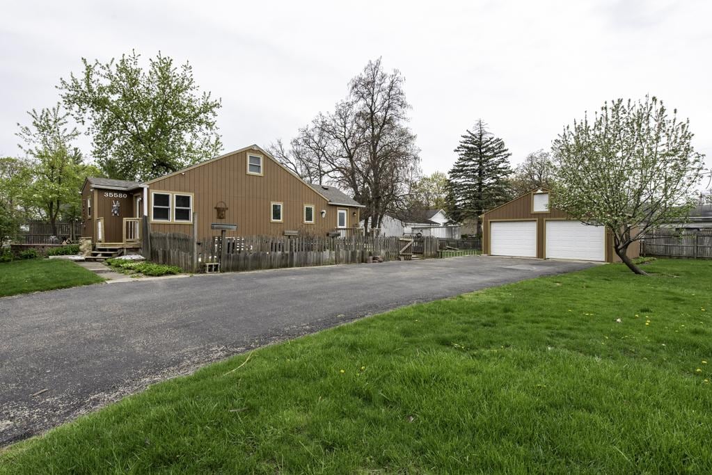 35580 N Sunnyside Ave, Ingleside, IL 60041 - view of side of home with fence private yard, a garage, and a lawn