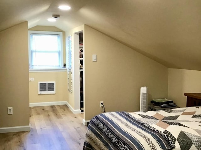 bedroom with baseboards, lofted ceiling, and light wood-type flooring