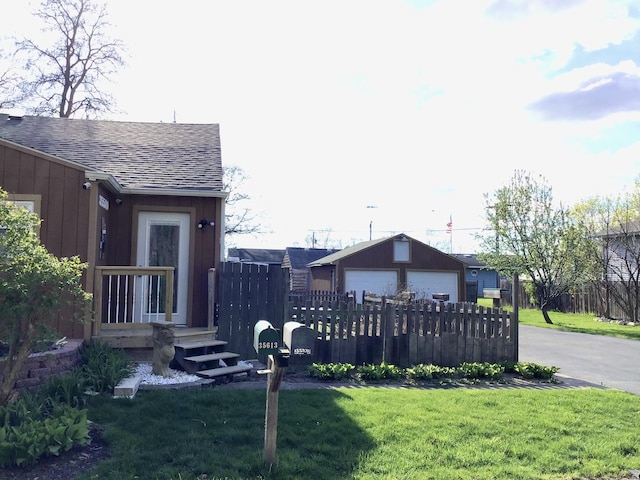 view of yard featuring fence, an outbuilding, and a garage