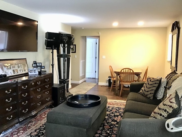 living area with baseboards, wood finished floors, and visible vents