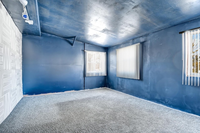 carpeted empty room with vaulted ceiling