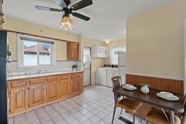 6449 W 84th St, Burbank, IL 60459 - kitchen with washer and clothes dryer, tasteful backsplash, healthy amount of natural light, freestanding refrigerator, and a wainscoted wall