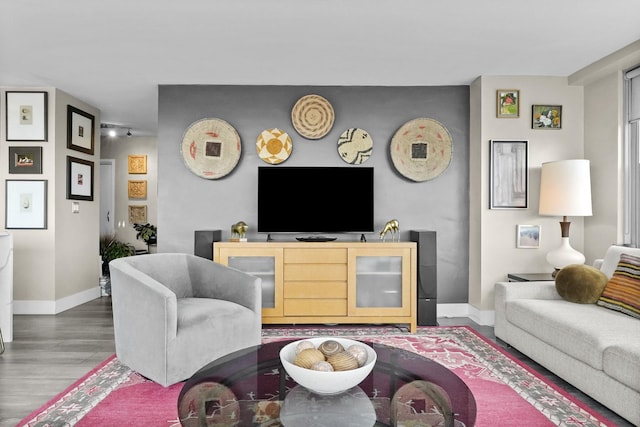 living area with baseboards and wood finished floors