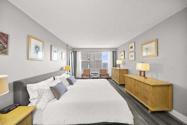 bedroom featuring dark wood-style floors and baseboards