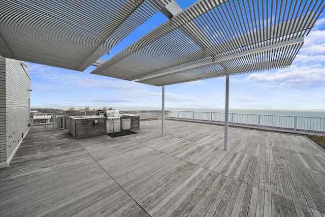 deck featuring exterior kitchen and a water view