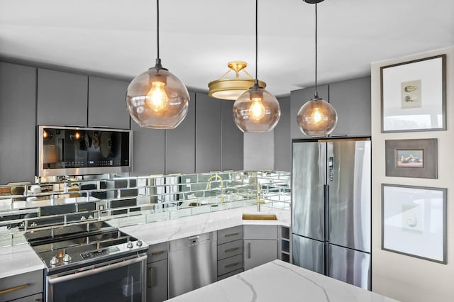 kitchen with backsplash, appliances with stainless steel finishes, gray cabinetry, and light stone countertops