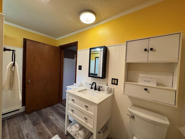 bathroom with a baseboard radiator, wood finished floors, a textured ceiling, crown molding, and toilet