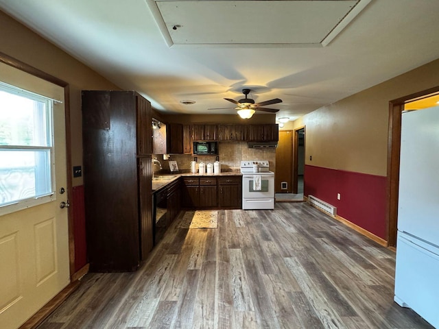 kitchen featuring black appliances, tasteful backsplash, dark wood-type flooring, light countertops, and a sink