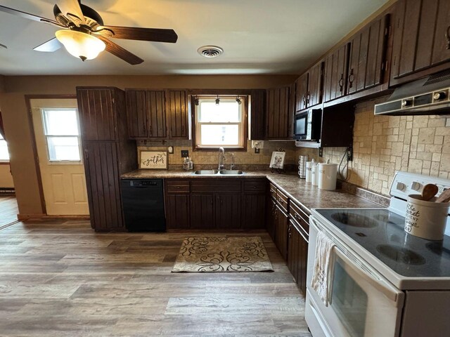 kitchen featuring black appliances, a sink, backsplash, under cabinet range hood, and dark brown cabinetry