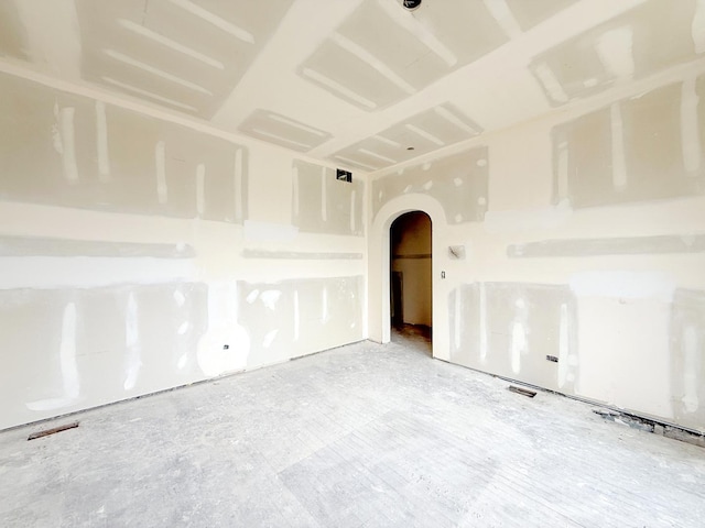 spare room featuring arched walkways