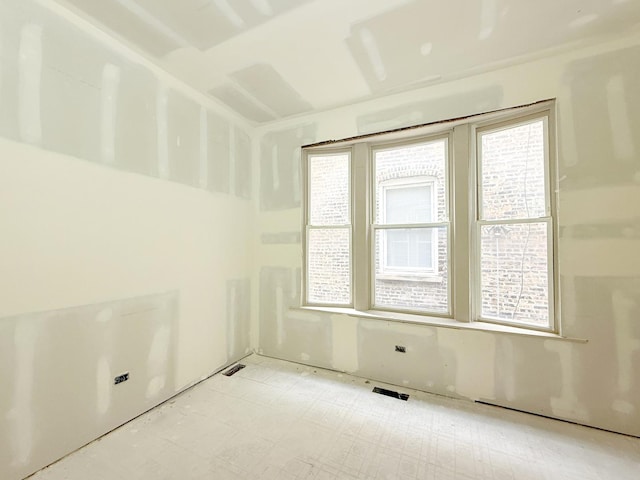 spare room with a wealth of natural light and visible vents