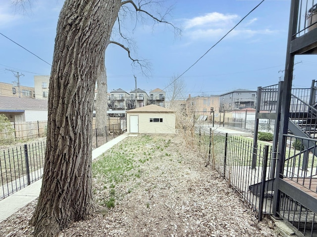 view of yard with an outdoor structure, a residential view, and fence