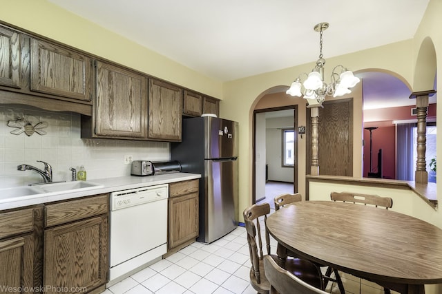 6430 W Belle Plaine Ave Unit 508, Chicago, IL 60634 - kitchen with light countertops, arched walkways, a sink, white dishwasher, and backsplash