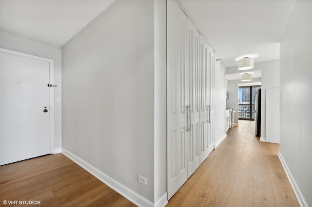 hallway with baseboards and light wood-style floors