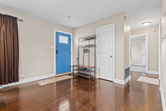foyer with wood finished floors, baseboards, and visible vents