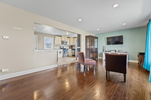 living room featuring recessed lighting, baseboards, and wood finished floors