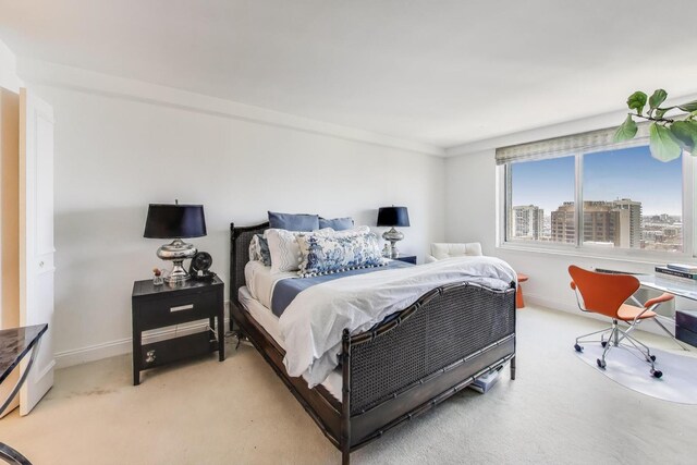 bedroom with baseboards and light colored carpet