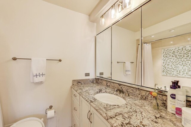 full bath featuring vanity, a shower with shower curtain, and toilet