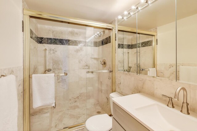 full bath featuring toilet, tile walls, a shower stall, and vanity