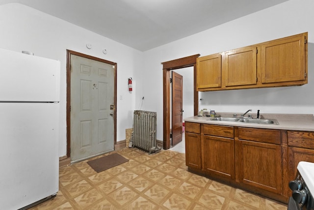 1913 N Kildare Ave, Chicago, IL 60639 - kitchen featuring light countertops, a sink, radiator heating unit, freestanding refrigerator, and brown cabinetry