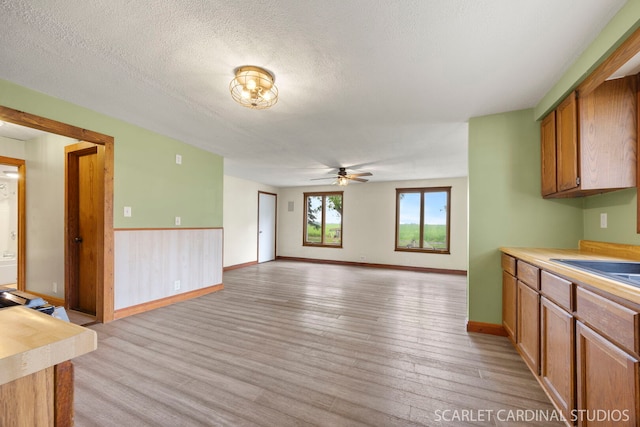 301 S Shabbona Rd, Shabbona, IL 60550 - kitchen with a ceiling fan, light wood-style flooring, brown cabinetry, light countertops, and a textured ceiling
