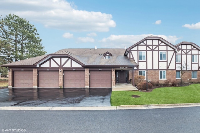 view of front of house with driveway, a front lawn, brick siding, a garage, and a shingled roof