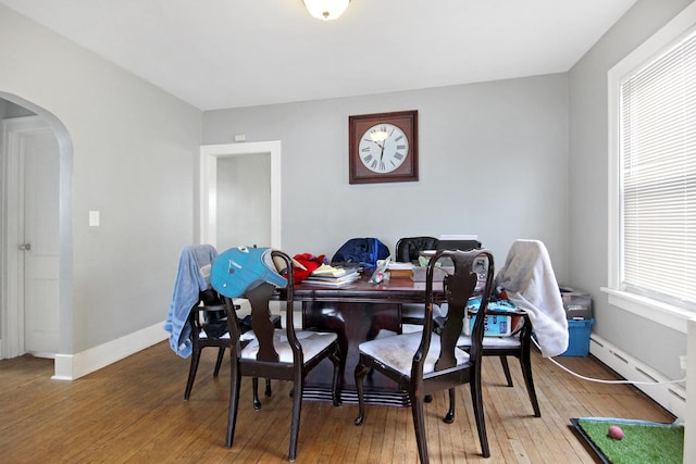 18241 Roy St, Lansing, IL 60438 - dining space with a baseboard heating unit, arched walkways, light wood-type flooring, and baseboards