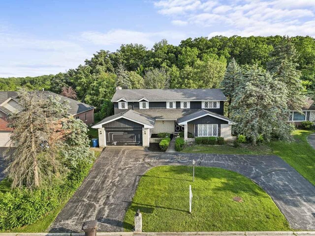 7415 W Ute Ln, Palos Heights, IL 60463 - traditional home featuring curved driveway, a front lawn, a chimney, and a garage