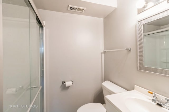 1437 S Busse Rd, Mount Prospect, IL 60056 - bathroom featuring a shower with shower door, toilet, and vanity