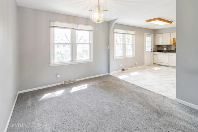1437 S Busse Rd, Mount Prospect, IL 60056 - unfurnished living room featuring light carpet, baseboards, and a chandelier