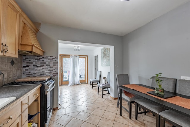 3801 W 65th Pl, Chicago, IL 60629 - kitchen featuring stove, backsplash, light tile patterned floors, a chandelier, and dark countertops