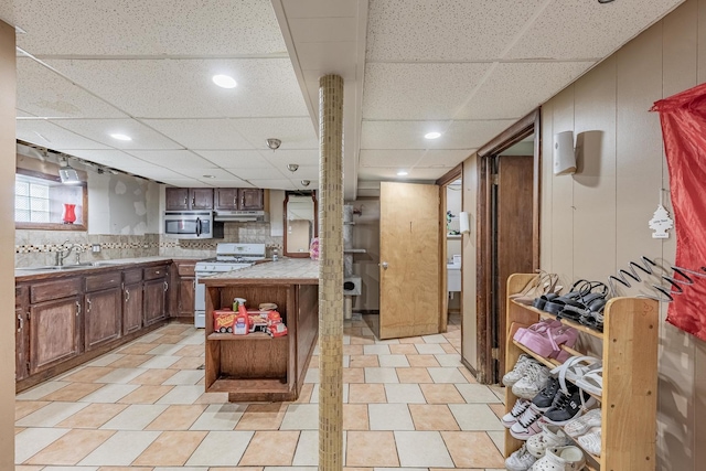 3801 W 65th Pl, Chicago, IL 60629 - kitchen with gas range gas stove, under cabinet range hood, open shelves, a paneled ceiling, and a sink