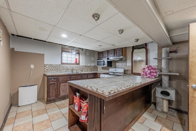 3801 W 65th Pl, Chicago, IL 60629 - kitchen with white range, a sink, tile counters, stainless steel microwave, and a paneled ceiling
