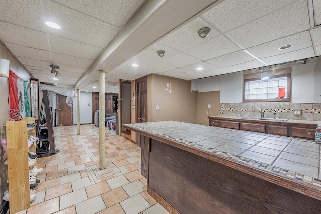 3801 W 65th Pl, Chicago, IL 60629 - kitchen featuring tile counters, a sink, a paneled ceiling, recessed lighting, and backsplash