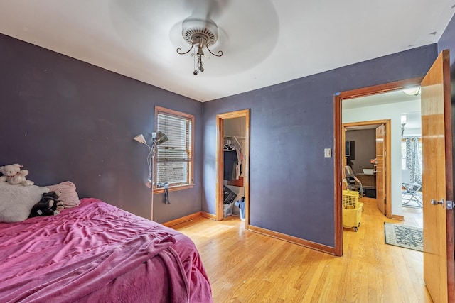3801 W 65th Pl, Chicago, IL 60629 - bedroom featuring wood finished floors, baseboards, a walk in closet, and a closet