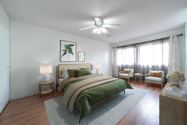 bedroom with dark wood-style floors, baseboards, and a ceiling fan