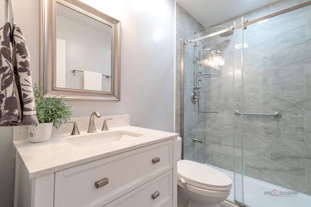 full bathroom with a shower stall, toilet, and vanity