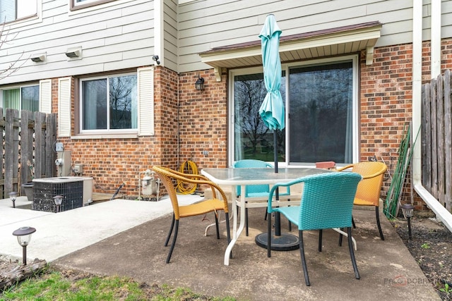 view of patio featuring central air condition unit, outdoor dining area, and fence