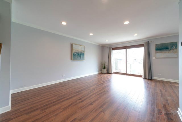 empty room featuring dark wood-style floors, baseboards, and ornamental molding
