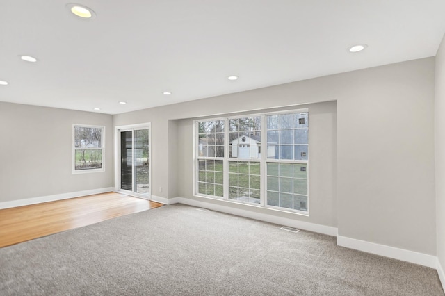 empty room featuring recessed lighting, visible vents, and baseboards