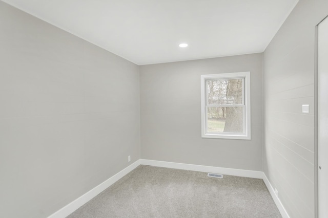 empty room with visible vents, baseboards, recessed lighting, and light carpet