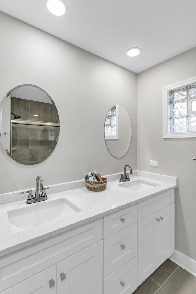 bathroom featuring tile patterned floors, double vanity, and a sink