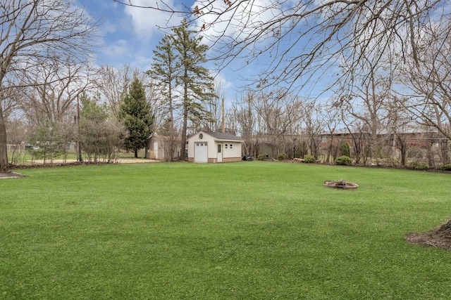 view of yard with a fire pit and an outdoor structure