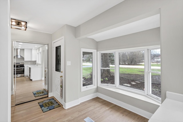 foyer with light wood-style floors and baseboards