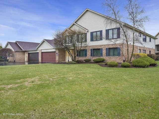 view of front of home featuring an attached garage, brick siding, and a front yard