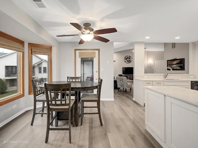 dining space featuring light wood finished floors, baseboards, ceiling fan, and visible vents