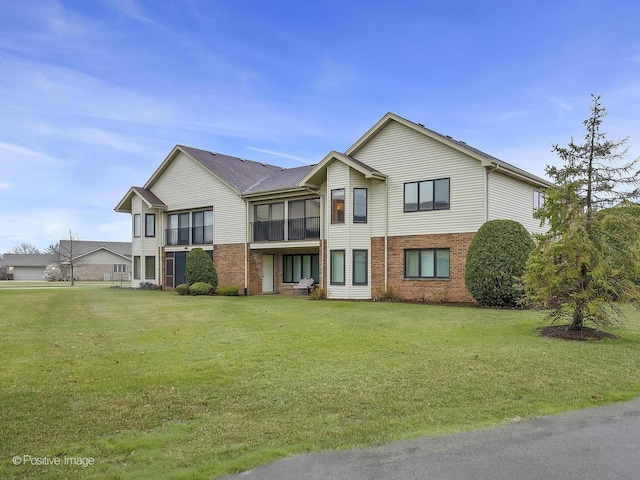 view of front of house featuring brick siding and a front yard