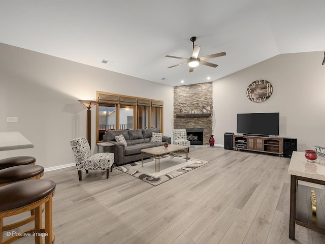 living area featuring visible vents, light wood-style flooring, a fireplace, ceiling fan, and lofted ceiling